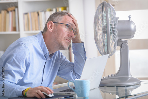 Man suffers from heat in the office or at home