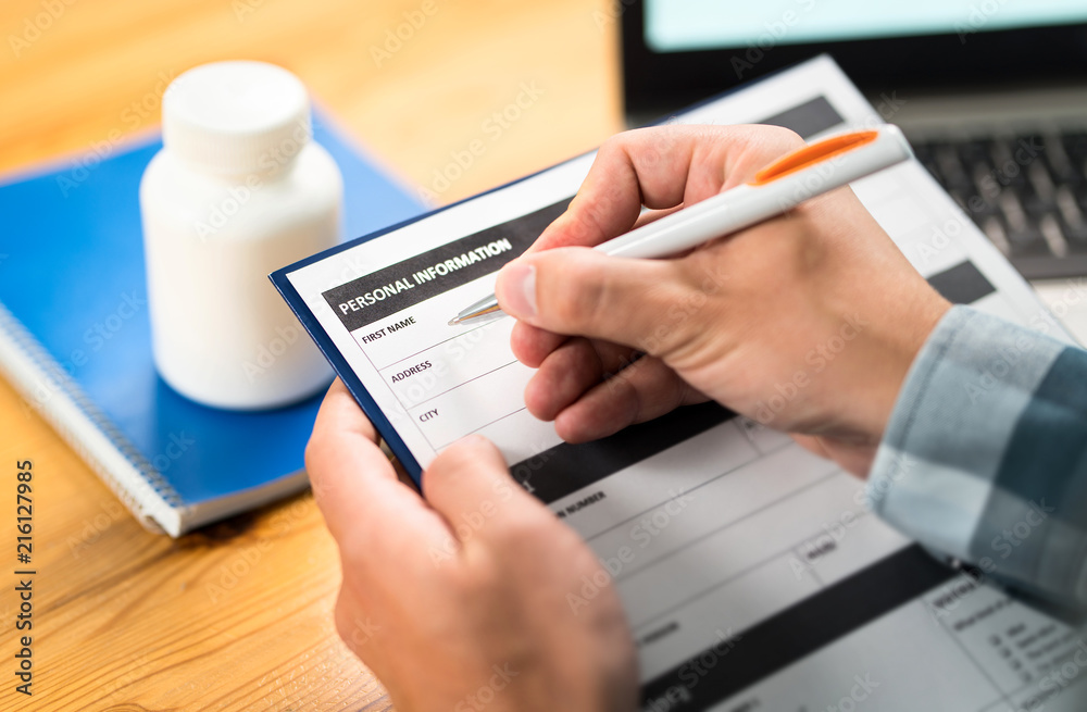 Man filling medical form for health insurance. Medicine research, survey or study. Patient or doctor writing personal information and medical data. Contract or agreement on paper. Man filling medical form for health insurance. Medicine research, survey or study. Patient or doctor writing personal information and medical data. Contract or agreement on paper.