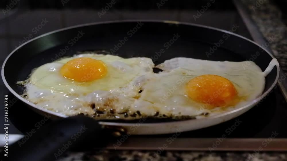 Two eggs being fried on the frying pan Two eggs being fried on the frying pan