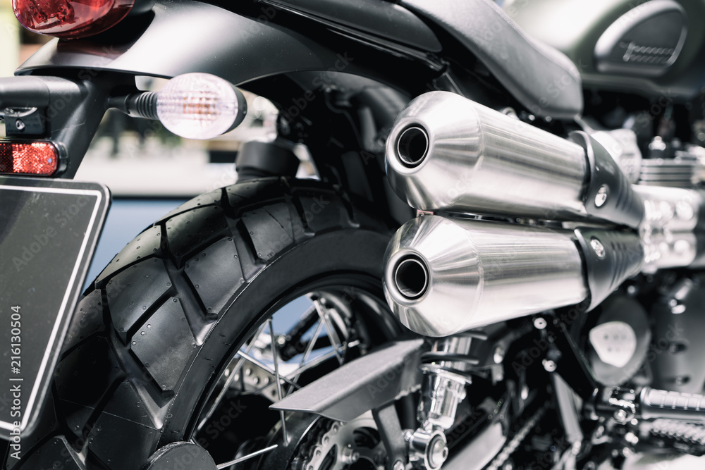 Close up shot of new motorcycle exhaust pipes. Rear view of a motorcycle with the focus on the chrome exhaust.