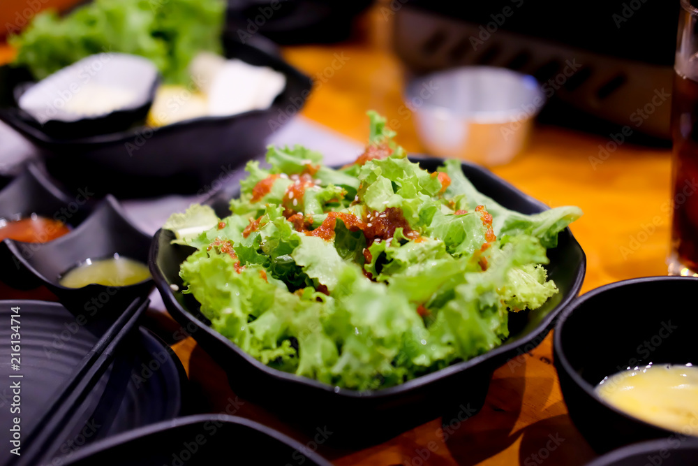 Lettuce with korean sour on black bowl Lettuce with korean sour on black bowl