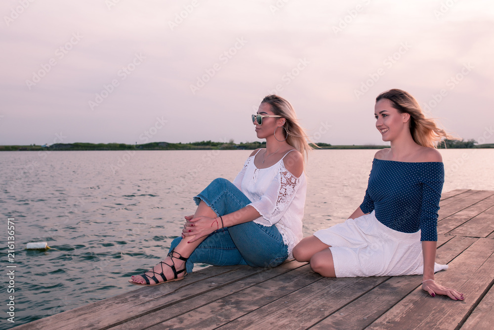 Beautiful young women sitting by the river