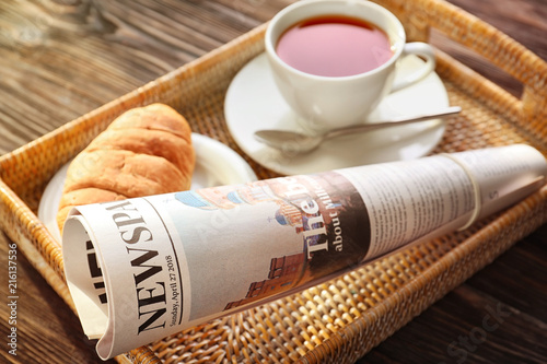 Tray with newspaper and cup...