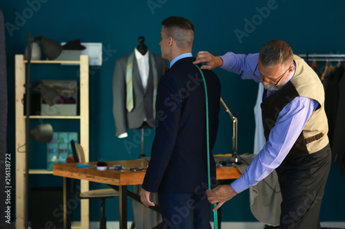 Mature tailor taking client...