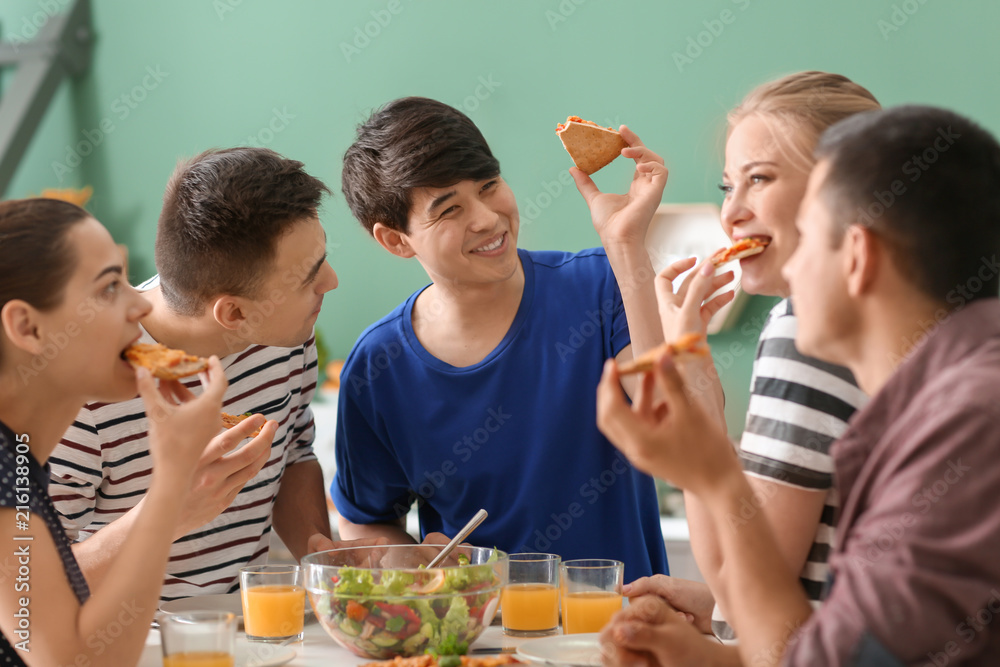 Friends eating at table in kitchen