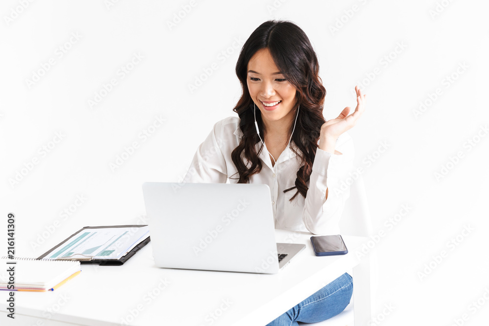 Photo of asian business woman 20s wearing office clothing looking at laptop, during video call or online conference, isolated over white background in studio Photo of asian business woman 20s wearing office clothing looking at laptop, during video call or online conference, isolated over white background in studio