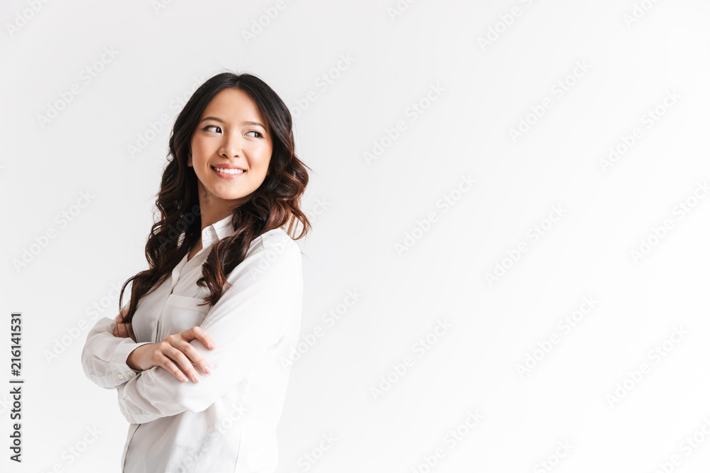 Portrait of young asian woman with long dark hair looking aside at copyspace with arms crossed, isolated over white background in studio Portrait of young asian woman with long dark hair looking aside at copyspace with arms crossed, isolated over white background in studio