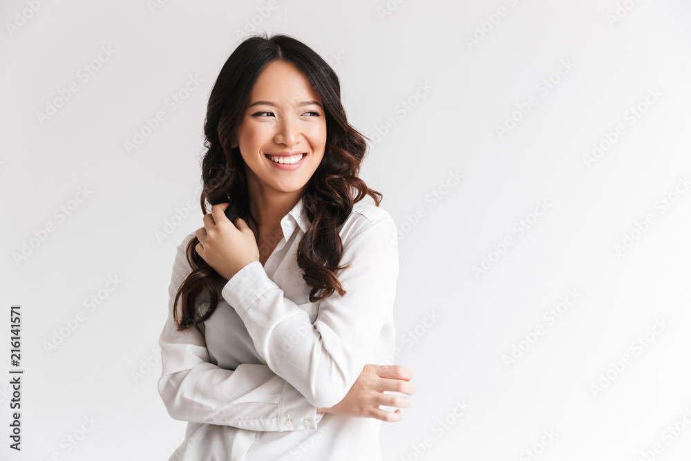 Photo of optimistic asian woman with long dark hair looking aside at copyspace and laughing, isolated over white background in studio Photo of optimistic asian woman with long dark hair looking aside at copyspace and laughing, isolated over white background in studio