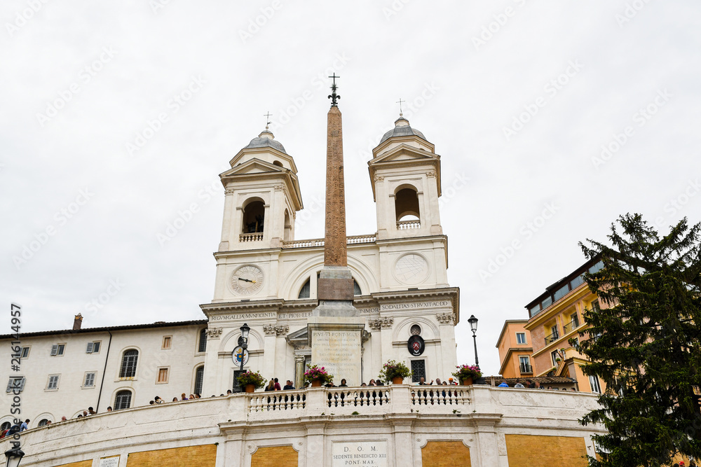 Obraz premium ローマ市内の古代遺跡（イタリア） スペイン階段の上のオベリスク（サルスティアーノ・オベリスク）と教会（トリニタ・デイ・モンティ教会）
