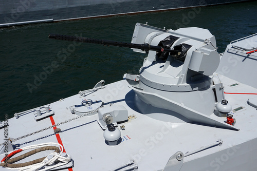 Naval ship artillery gun barrel on a blue sea background. copy space, selective focus, narrow depth of field