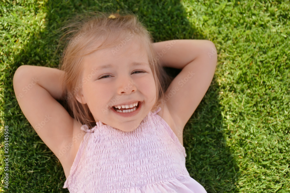 Cute little girl relaxing in park on sunny day Cute little girl relaxing in park on sunny day