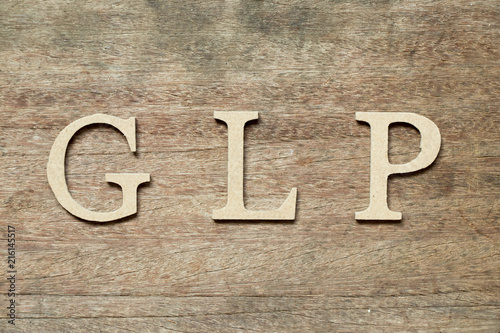 English alphabet in word GLP (Abbreviation of Good laboratory practice) on wood background photo