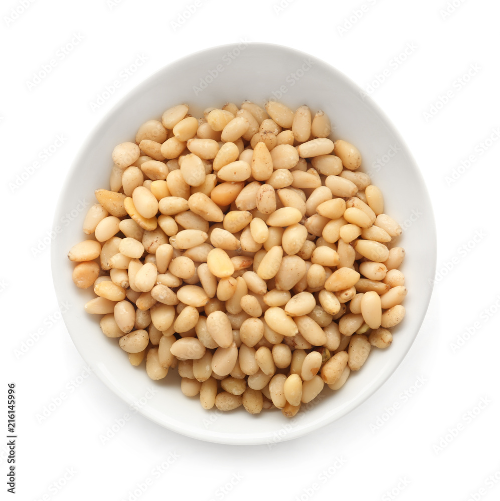 Bowl with tasty pine nuts on white background Bowl with tasty pine nuts on white background