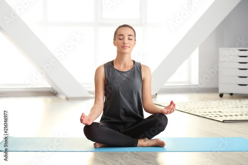 Young woman practicing yoga...
