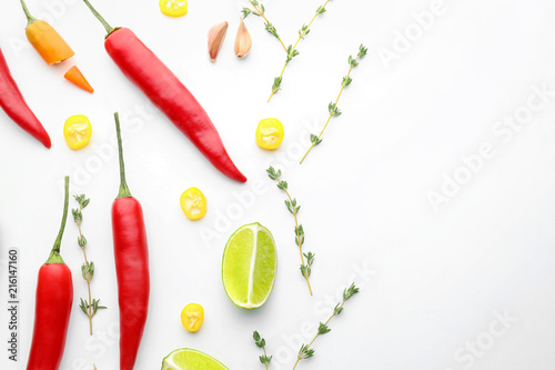 Composition with fresh chili peppers and herbs on white background
