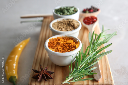 Bowls with different dry spices on wooden board