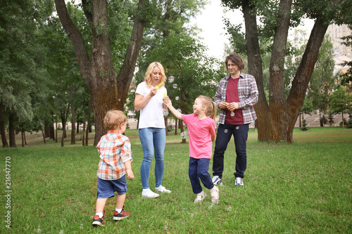 Happy family blowing soap b...