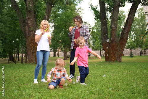 Happy family blowing soap b...