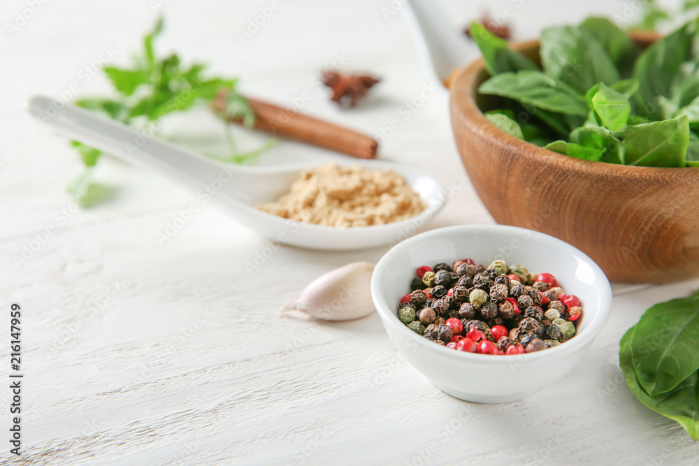 Composition with different spices and herbs on white wooden background Composition with different spices and herbs on white wooden background