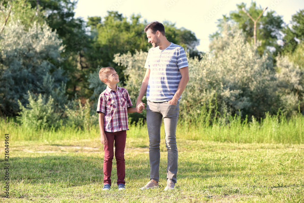 Father and son in park on summer day Father and son in park on summer day