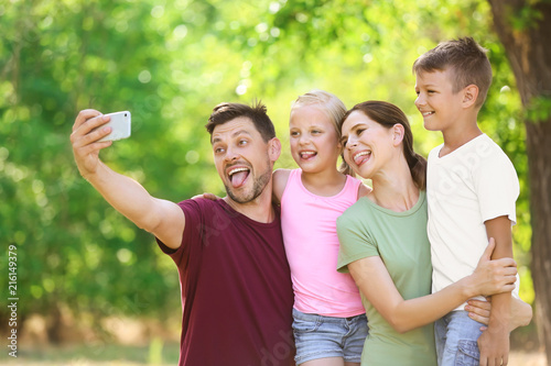 Happy family taking selfie in park