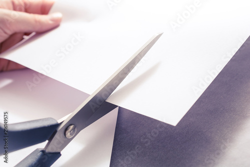Pair Of Scissors Cutting White Paper, Holded By Female Hands