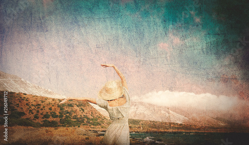 Caucasian girl in hat and white dress on sea coast in summertime. Stomio region, west Crete, Greece. Image in retro style photo