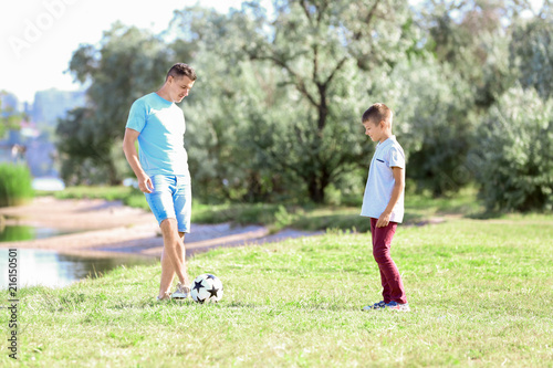 Father with son playing football outdoors