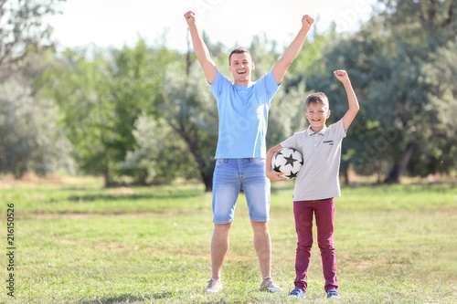 Happy boy and his dad with soccer ball outdoors © Pixel-Shot