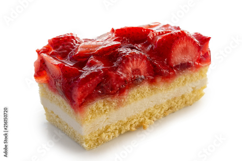 Slice of sponge cake topped with strawberries and jelly isolated on white.
