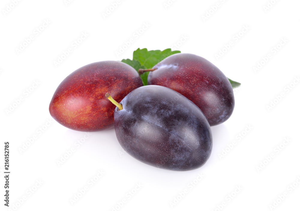 whole fresh prunes with leaf on white background whole fresh prunes with leaf on white background