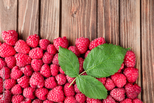 Ripe aromatic raspberries on wooden background