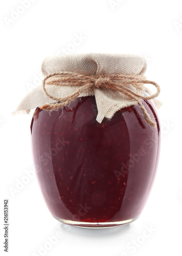 Glass jar with raspberry jam on white background