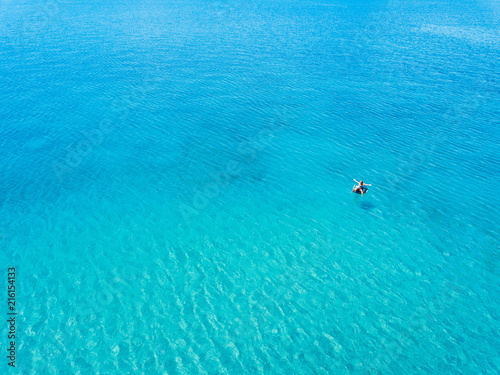 Aerial view of woman floating on the water mattress in the turquoise sea © marjan4782