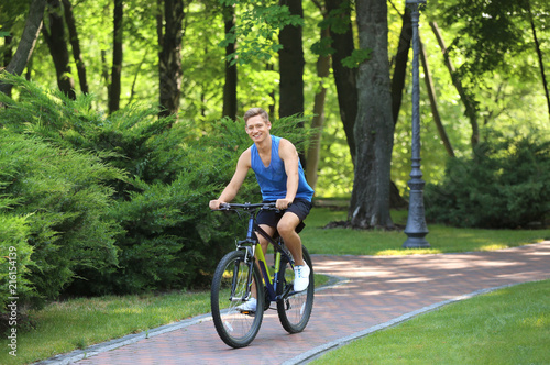 Young man riding bicycle in park © Pixel-Shot