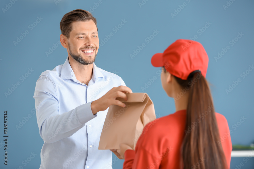 Young woman delivering food to customer indoors