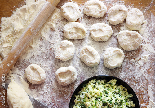 Process of preparation of patties. The filling consists of onions and eggs. Pirozhok - a dish of Russian and European cuisine from the dough with stuffing. Selective focus, copy space. photo