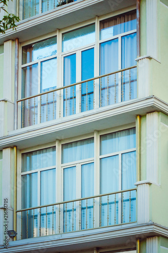 Fragment of the facade of a modern apartment house with a window and a balcony.