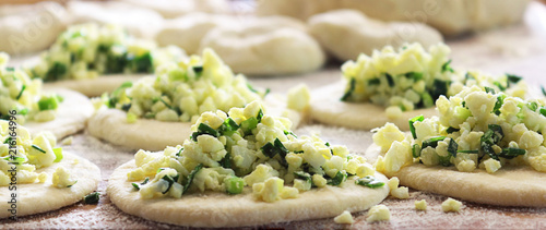 Process of preparation of patties. The filling consists of onions and eggs. Pirozhok - a dish of Russian and European cuisine from the dough with stuffing. Selective focus, copy space. Banner photo