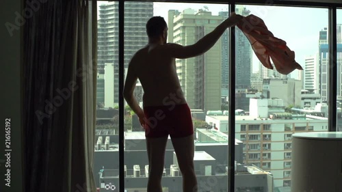 Man wearing only underwear and admiring the view from the window
 photo