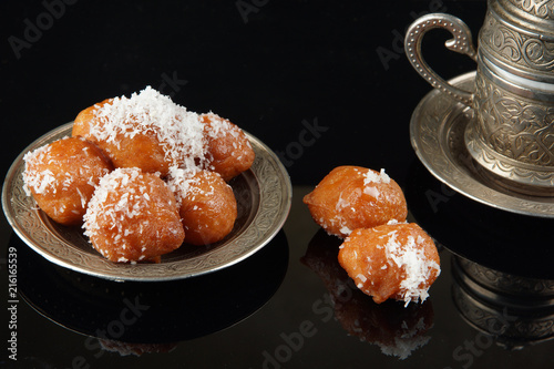 Turkish dessert on a plate next to a cup of coffee photo