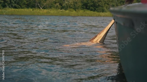 Paddle rowing in the water in slow motion. There is an open space to add text in the water. photo