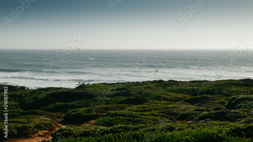 Portuguese flag at Guincho beach in Cascais, Portugal, a popular kitesurfing spot