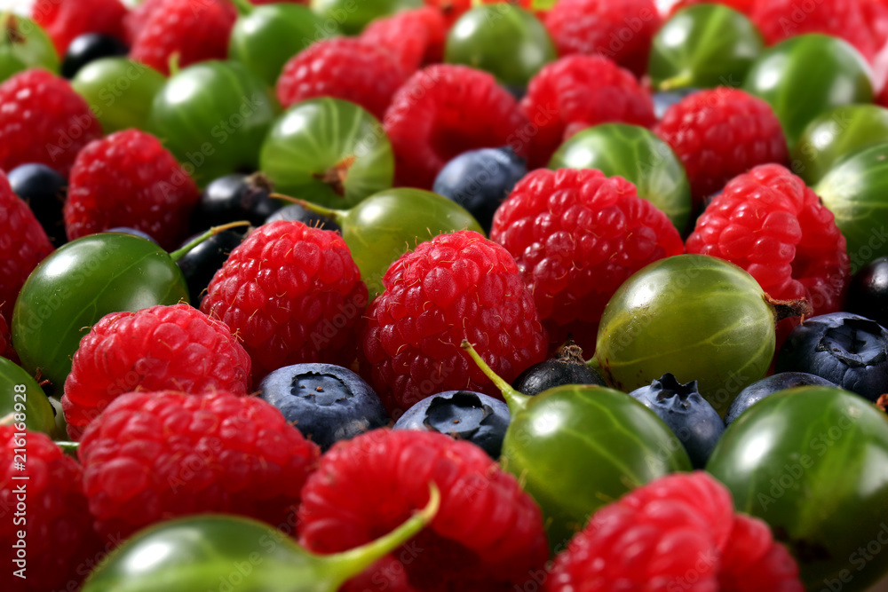 Obraz premium Fresh mixed berries assortment with raspberries, blueberries, and gooseberries for healthy eating and nutrition