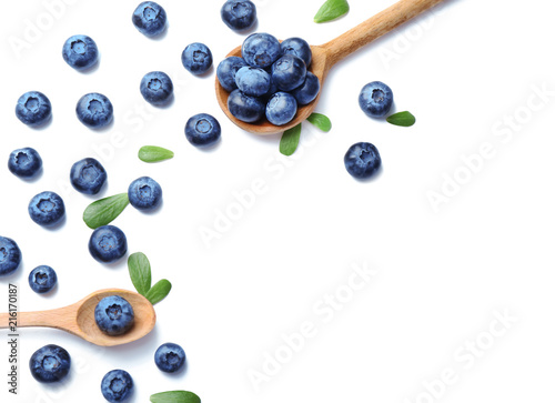 Wooden spoons with ripe blueberries on white background