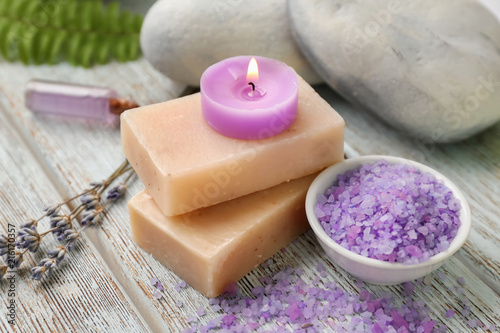 Spa composition with beautiful lavender  soap  sea salt and burning candle on wooden table