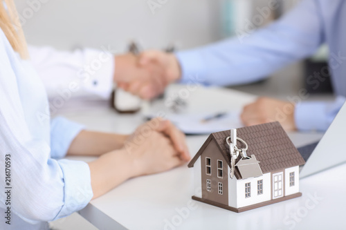 House model with key on table in office of real estate