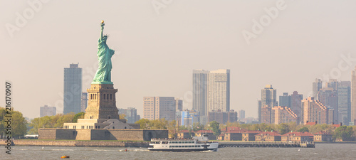 Statue of Liberty with Liberty State Park and Jersey City skyscrapers in background, USA. photo