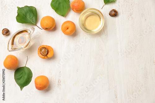 Composition with apricot essential oil on white wooden background