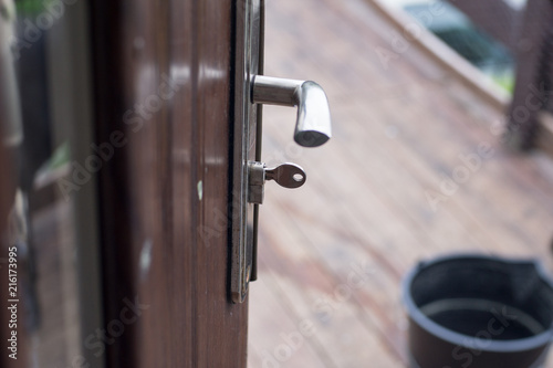 Opened house door, you can see what is outside. Door handle and key.